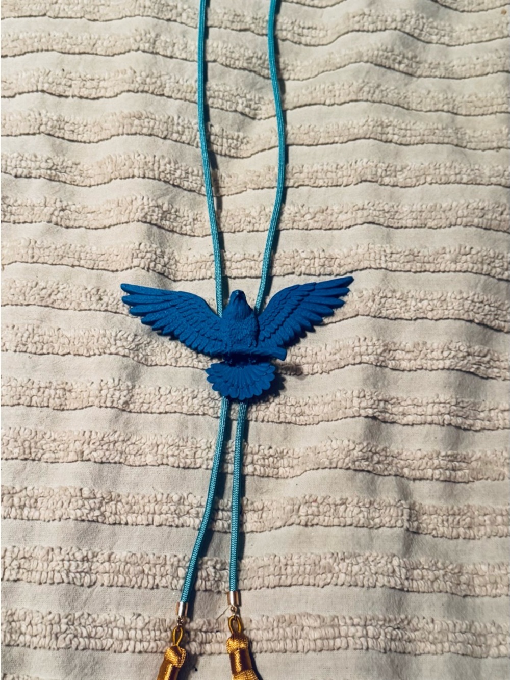 Eagle bolo with turquoise cord and mustard color tassels
